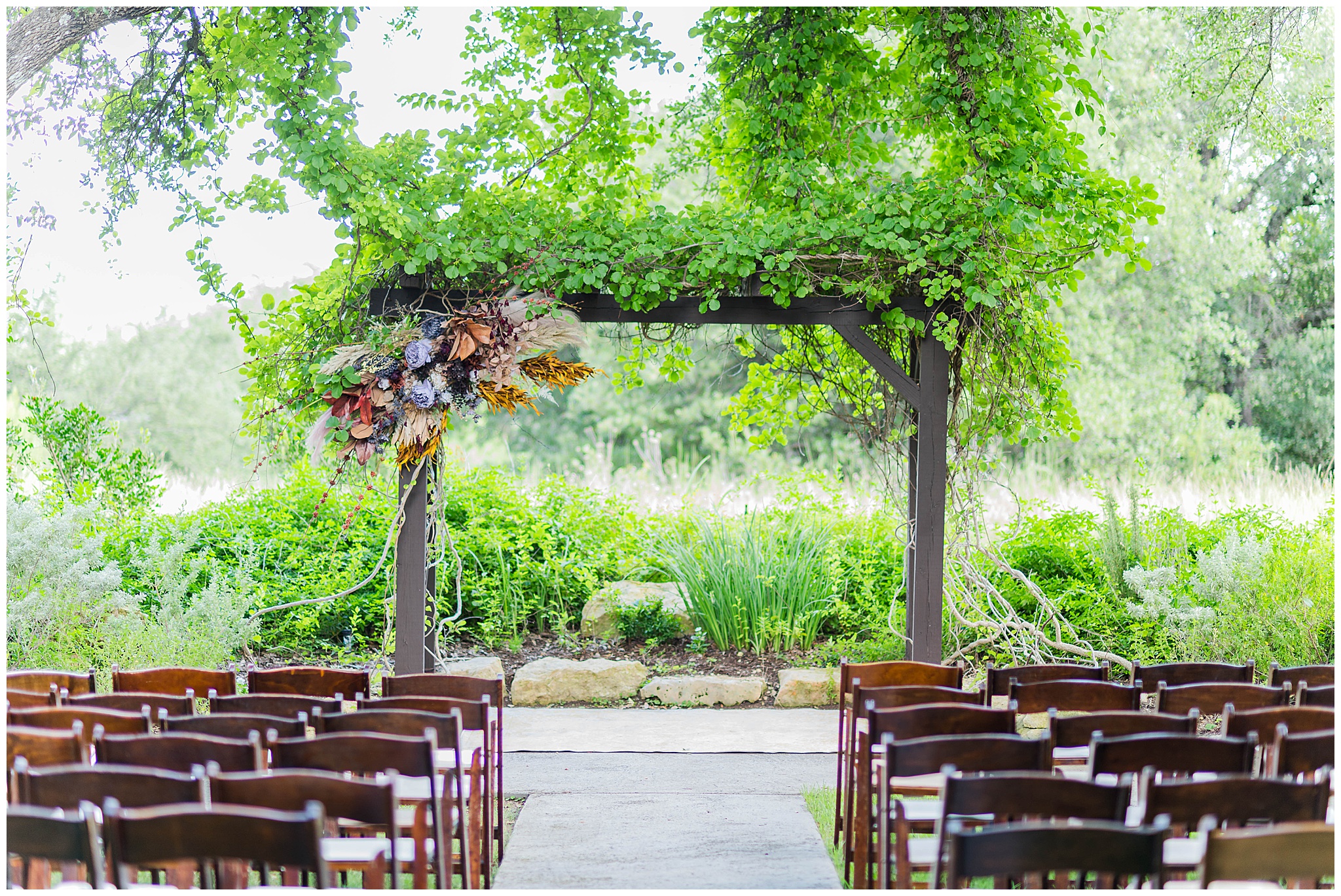 Outdoor Ceremony with an asymmetrical floral arbor.