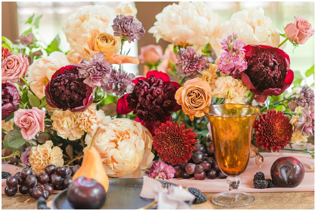 Centerpiece by Belle Soul Florals in peach, reds, creams. 