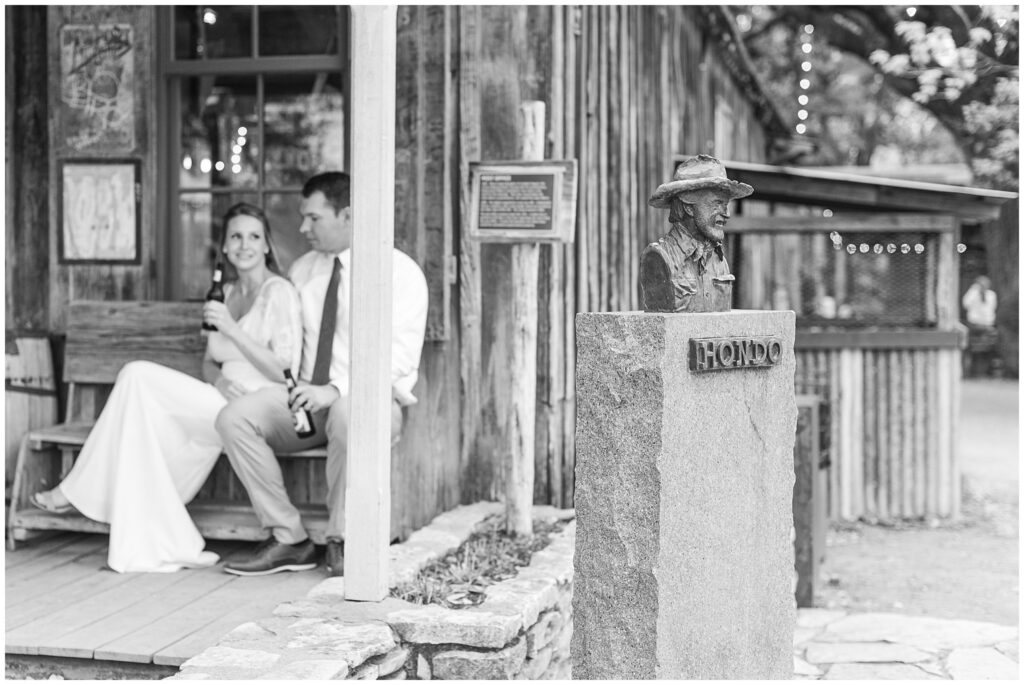 Elopement in Luckenbach Texas. Bride and Groom sharing a beer while sitting at the Post Office in Luckenbach TX. Photo taken by Dripping Springs TX based Lydia Teague Photography. 